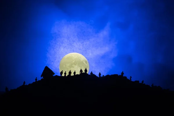 Vue effrayante foule de zombies sur la colline avec ciel nuageux effrayant avec brouillard et pleine lune montante. Groupe de silhouette de zombie marchant sous la pleine lune . — Photo