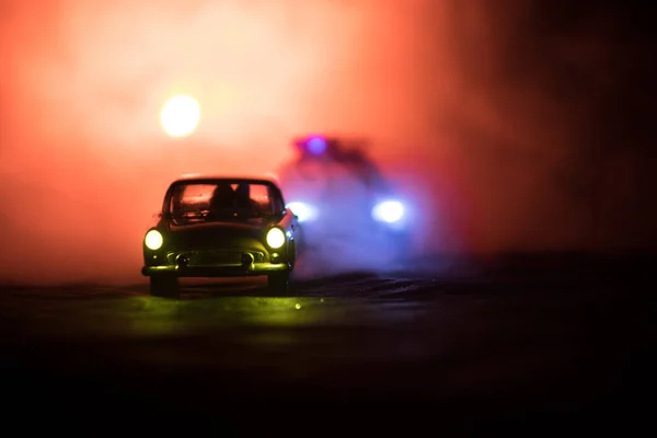 Leksak Bmw polisbil jagar en Ford Thunderbird bil på natten med dimma bakgrund. Leksak dekoration scen på bordet. Selektivt fokus - 11 Jan 2018, Baku Azerbajdzjan — Stockfoto