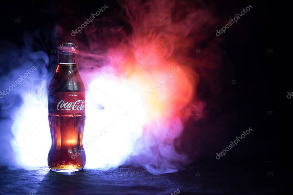 Baku, Azerbaijan 13th January 2018, Coca-Cola Classic in a glass bottle on dark toned foggy Background. Coca Cola, Coke is the most popular carbonated soft drink beverages sold around the world