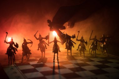 Süvari ve satranç tahtası üzerinde piyade ile ortaçağ savaş sahnesi. Satranç oyununu kavramı iş fikirleri ve rekabet ve strateji fikirler satranç karanlık bir arka plan üzerinde rakamlar. Seçici odak