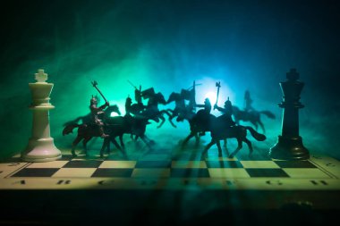 Süvari ve satranç tahtası üzerinde piyade ile ortaçağ savaş sahnesi. Satranç oyununu kavramı iş fikirleri ve rekabet ve strateji fikirler satranç karanlık bir arka plan üzerinde rakamlar. Seçici odak