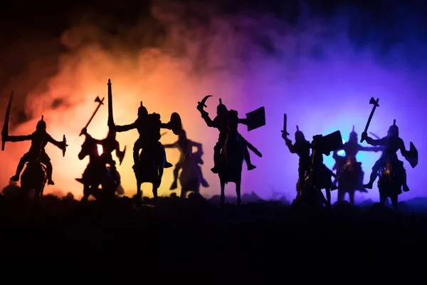 Escena de batalla medieval con caballería e infantería. Siluetas de figuras como objetos separados, lucha entre guerreros sobre fondo de niebla tonificado oscuro. Escena nocturna . — Foto de Stock