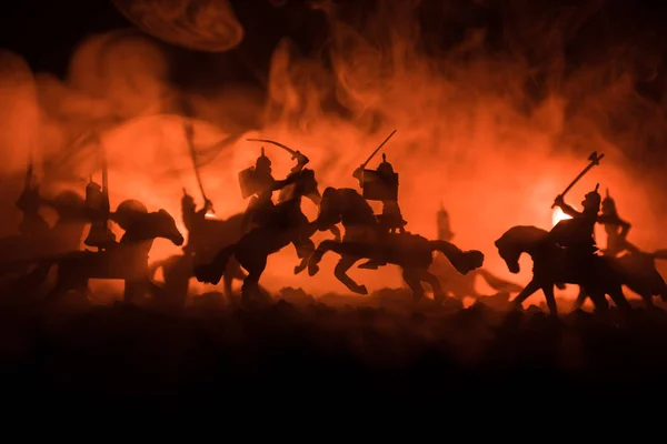 Μεσαιωνική μάχη σκηνή με ιππικό και πεζικό. Σιλουέτες των αριθμών ως ξεχωριστά αντικείμενα, καταπολέμηση μεταξύ πολεμιστές σε σκούρο τονισμένο ομιχλώδες φόντο. Σκηνή νύχτα. — Φωτογραφία Αρχείου