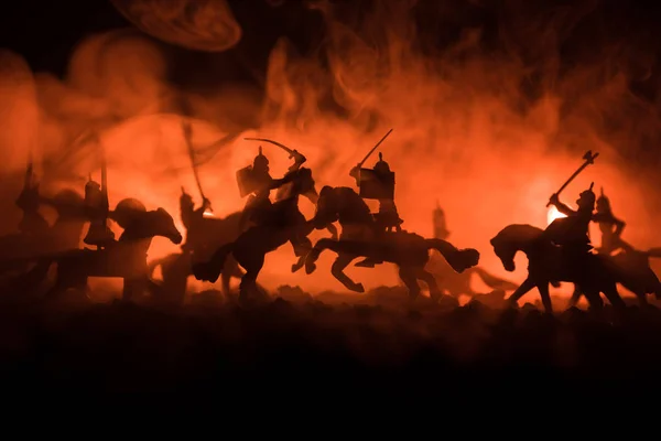 Medieval battle scene with cavalry and infantry. Silhouettes of figures as separate objects, fight between warriors on dark toned foggy background. Night scene. — Stock Photo, Image