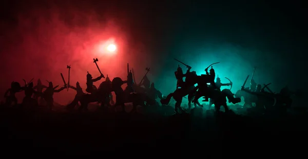 Cena de batalha medieval com cavalaria e infantaria. Silhuetas de figuras como objetos separados, luta entre guerreiros em fundo enevoado escuro. Cena noturna . — Fotografia de Stock