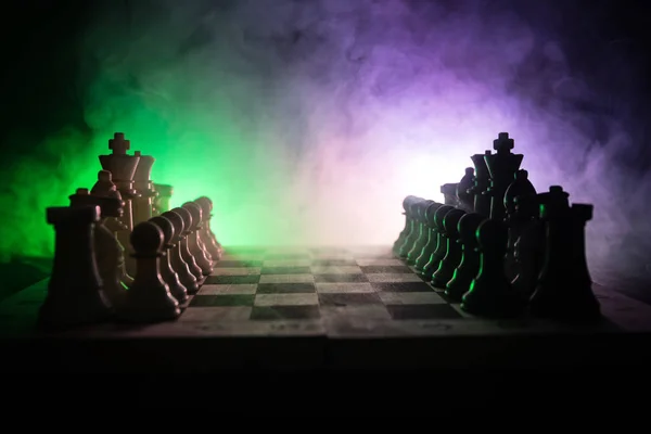 Schaken bordspel concept van bedrijfsideeën en concurrentie en strategie ideeën concep. Chess cijfers op een donkere achtergrond met rook en mist. Leiderschap en vertrouwen bedrijfsconcept. — Stockfoto