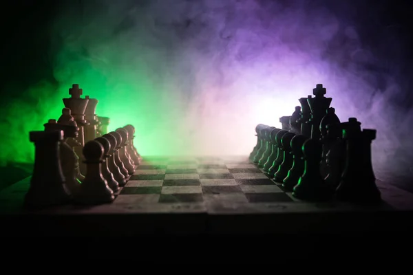 Jeu d'échiquier concept d'idées d'affaires et de la concurrence et des idées de stratégie concéder. Chess figures sur un fond sombre avec de la fumée et du brouillard. Leadership d'entreprise et concept de confiance . — Photo