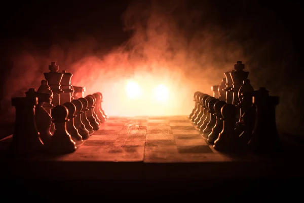 Šachy desková hra koncept podnikatelských nápadů a precizní strategie a soutěž myšlenek. Šachové figury na tmavém pozadí se kouře a mlhy. Obchodní vedení a důvěru koncept. — Stock fotografie
