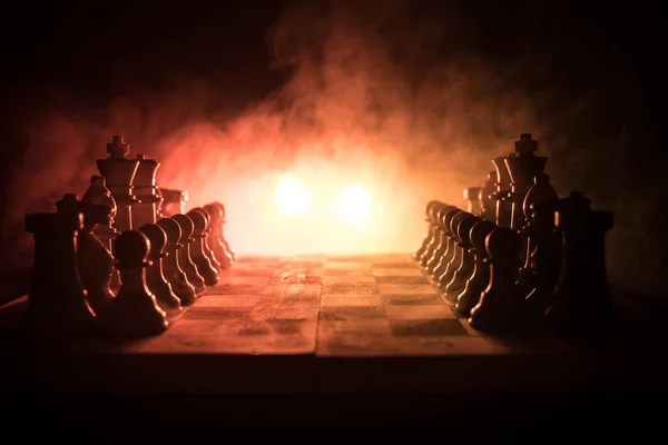 Schaken bordspel concept van bedrijfsideeën en concurrentie en strategie ideeën concep. Chess cijfers op een donkere achtergrond met rook en mist. Leiderschap en vertrouwen bedrijfsconcept. — Stockfoto