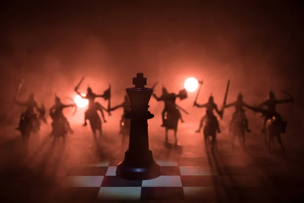Μεσαιωνική μάχη σκηνή με ιππικό και πεζικό στη σκακιέρα. Έννοια επιτραπέζιο παιχνίδι σκάκι επιχειρηματικές ιδέες και ανταγωνισμού και ιδέες στρατηγική σκάκι φιγούρες σε σκούρο φόντο. Επιλεκτική εστίαση — Φωτογραφία Αρχείου