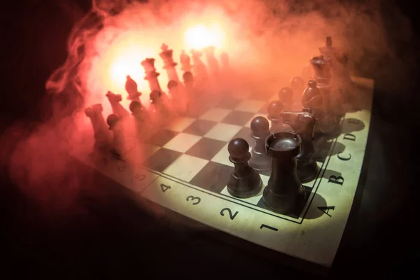 Chess board game concept of business ideas and competition and strategy ideas concep. Chess figures on a dark background with smoke and fog. Business leadership and confidence concept. — Stock Photo, Image