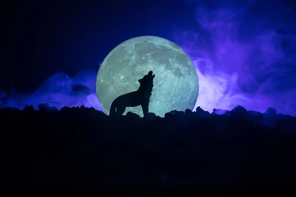 Silueta de lup urlând pe fundal cețos tonifiat întunecat și lună plină sau lup în siluetă urlând la luna plină. Conceptul de horror de Halloween . — Fotografie, imagine de stoc