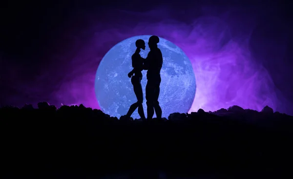 Силуэт пары, целующейся в полнолуние. Парень целует девушку за руку на фоне силуэта полнолуния. День святого Валентина концепция декора. Силуэт любящей пары, целующейся против луны — стоковое фото