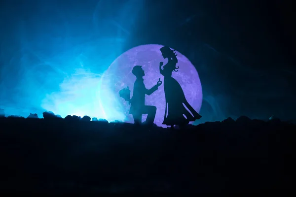 Increíble escena de amor. Siluetas de hombre haciendo propuesta a la mujer o Siluetas de pareja contra la luna grande en el fondo — Foto de Stock