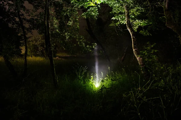 Strana silhouette in una foresta oscura spettrale di notte, paesaggio mistico luci surreali con uomo inquietante — Foto Stock