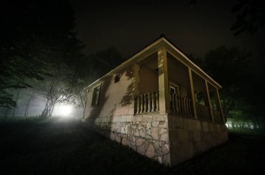 Orman, binada sisli gece moon ile dağ gece manzarası. Yeşil çayır, büyük ağaçlar ve terk edilmiş evde gece. Gece çekimi