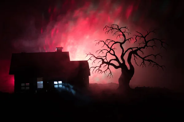 Oud huis met een spook at night met spooky boom of verlaten Haunted Horror House in afgezwakt mistige hemel met licht. Oude mystic gebouw in dode boom bos. Halloween concept. — Stockfoto