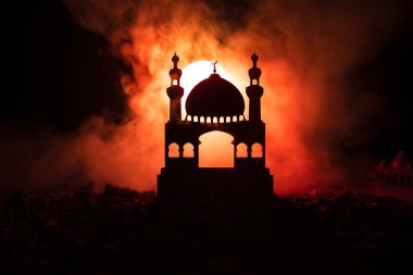 Cami binasında silüeti sisli arka plan tonda. Ramazan Kareem arka plan. Gün batımında Camii. İnsanlar dua. Seçici odak