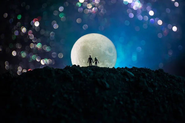 Geweldige scène van de liefde. Silhouetten van jong romantische koppel staande onder de maanlicht — Stockfoto