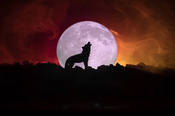 Silueta vyjící vlk proti tmavě tónovaný zamlžené pozadí a úplněk nebo vlk silueta vytí na měsíc. Pojem horor Halloween. — Stock fotografie