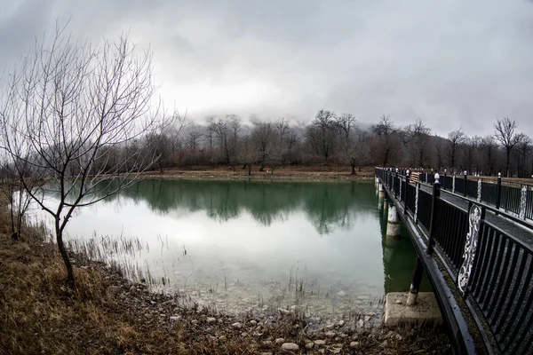 Erstaunliche Landschaft der Brücke spiegeln sich auf Oberflächenwasser des Sees, Nebel verdunsten aus Teich machen romantische Szene oder schöne Brücke über den See mit Bäumen bei Nebel. — Stockfoto