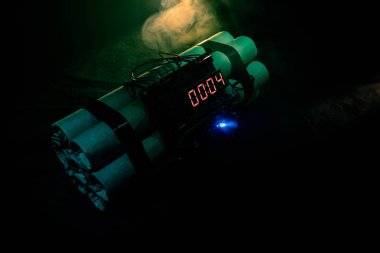 Image of a time bomb against dark background. Timer counting down to detonation illuminated in a shaft light shining through the darkness clipart