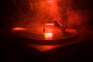 Pikap vinil plak çalar. Retro ses ekipmanları için disk jokey. Dj mix ve müzik çalmak için ses teknolojisi. Yangın arka plan yanan karşı oynanan vinil kaydı