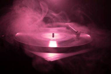 Pikap vinil plak çalar. Retro ses ekipmanları için disk jokey. Dj mix ve müzik çalmak için ses teknolojisi. Yangın arka plan yanan karşı oynanan vinil kaydı