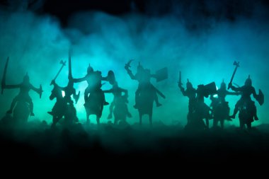 Süvari ve piyade ile ortaçağ savaş sahnesi. Siluetleri şekiller ayrı nesneler olarak mücadele koyu tonda sisli arka plan savaşçılar arasında. Gece çekimi.