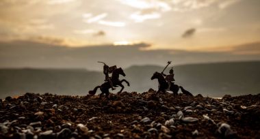 Joust between two knights on horseback. Sunset on background. Selective focus clipart