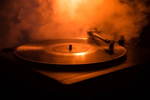 Turntable vinyl record player. Retro audio equipment for disc jockey. Sound technology for DJ to mix & play music. Vinyl record being played against burning fire background — Stock Photo, Image