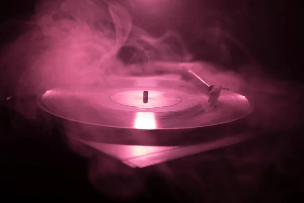 Turntable vinyl record player. Retro audio equipment for disc jockey. Sound technology for DJ to mix & play music. Vinyl record being played against burning fire background — Stock Photo, Image