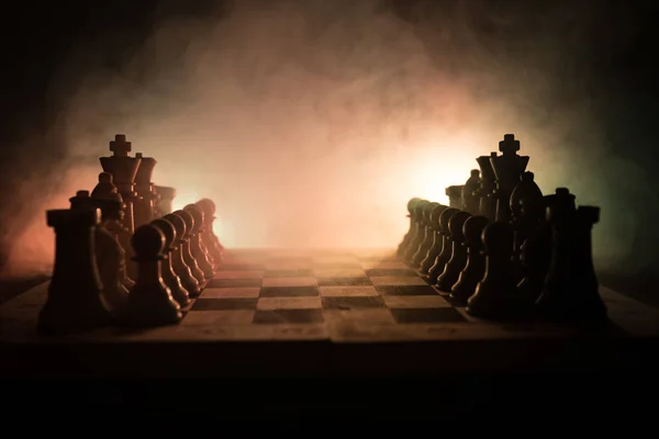 Schaken bordspel concept van bedrijfsideeën en concurrentie en strategie ideeën concep. Chess cijfers op een donkere achtergrond met rook en mist. Leiderschap en vertrouwen bedrijfsconcept. — Stockfoto