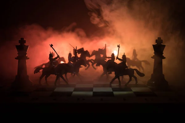 Middeleeuwse slag scène met de cavalerie en infanterie op een schaakbord. Schaken bordspel concept van bedrijfsideeën, concurrentie en strategie ideeën Chess cijfers op een donkere achtergrond. Selectieve aandacht — Stockfoto