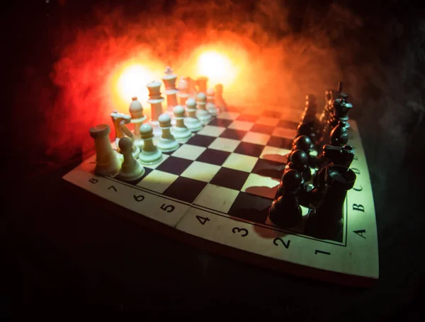 Schaken bordspel concept van bedrijfsideeën en concurrentie en strategie ideeën concep. Chess cijfers op een donkere achtergrond met rook en mist. Leiderschap en vertrouwen bedrijfsconcept. — Stockfoto