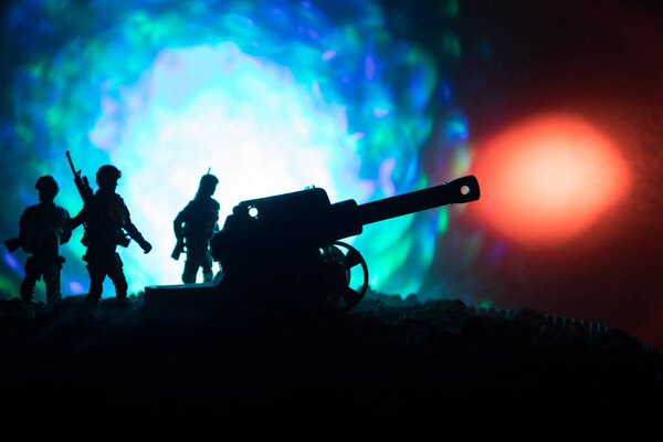 Сцена сражения с артиллерией и стоячими солдатами. Силуэт старого полевого орудия, стоящего на поле, готового стрелять. С ярким темным туманным фоном
.