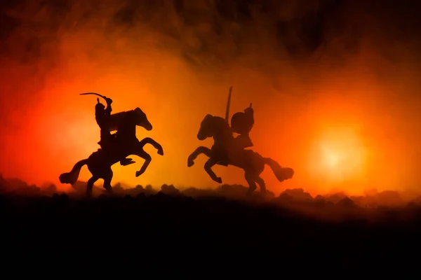 Středověká bitva scény s jezdectva a pěchoty. Siluety postav jako samostatné objekty, boj mezi bojovníky na tmavém tónovaný zamlžené pozadí. Noční scéna. — Stock fotografie
