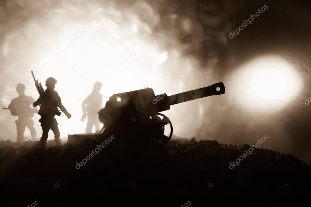 Battle scene with arillery and standing soldiers. Silhouette of old field gun standing at field ready to fire. With colorful dark foggy background.