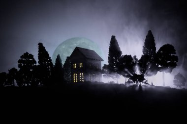 Eski ev gece ormanda bir hayalet veya siste perili korku evi terk etti. Ölü ağaç orman eski mistik binada. Ağaçlar moon ile gece. Gerçeküstü ışıklar