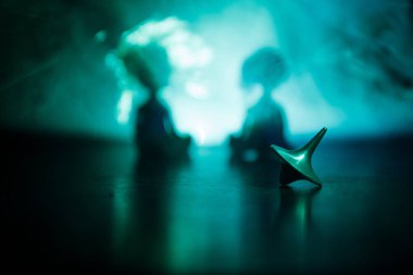 Totem iplik üst iplik, wobbling ve durdurma. Üst tonda duman arka ışıklı ayna yüzeyinde iplik. Eğlenceyi eylem masada karanlık odada.