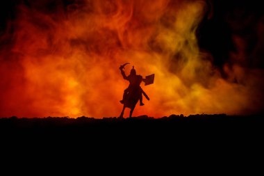 Süvari ve piyade ile ortaçağ savaş sahnesi. Siluetleri şekiller ayrı nesneler olarak mücadele koyu tonda sisli arka plan savaşçılar arasında. Gece çekimi.