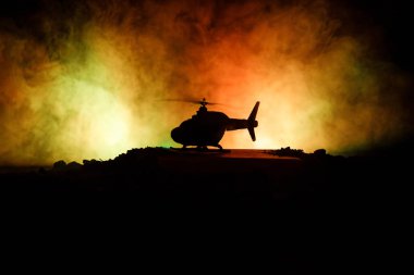 Askeri helikopter çatışma bölgesinden uçmaya hazır silüeti. Gece görüntüleri çöl sisli tonda sırt ile başlayarak helikopter ile dekore edilmiştir. Seçici odak.