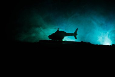 Askeri helikopter çatışma bölgesinden uçmaya hazır silüeti. Gece görüntüleri çöl sisli tonda sırt ile başlayarak helikopter ile dekore edilmiştir. Seçici odak.