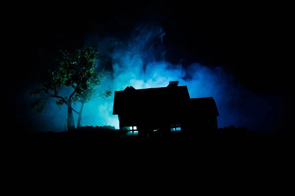 Old house with a Ghost in the forest at night or Abandoned Haunted Horror House in fog. Old mystic building in dead tree forest. Trees at night with moon. Surreal lights — Stock Photo, Image