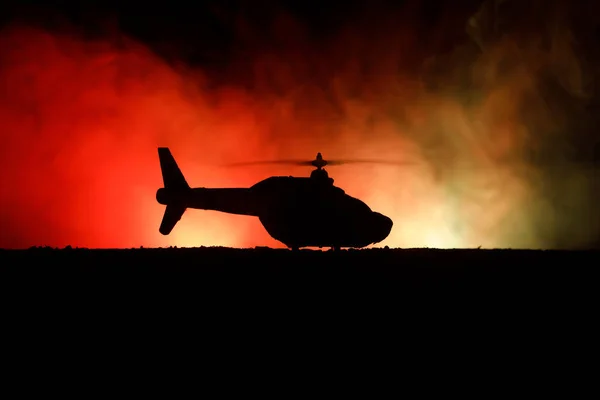 Silueta vojenský vrtulník připravený k letu z oblastí ozbrojených konfliktů. Noční záběry zdobené vrtulník v poušti s mlhavé tónovaný podsvícení. Selektivní fokus. — Stock fotografie