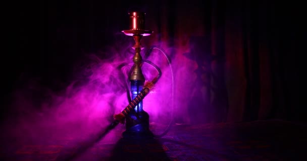 水烟碗上的水烟热煤制作阿拉伯内部的蒸汽云 地毯上的东方装饰品 时尚的东方水烟在黑暗中与背光 水烟旋转显示 滑块射击 — 图库视频影像
