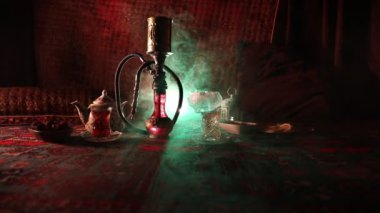 Nargile kömürü nargile kupa Arap iç de buhar bulutları yapma. Şark süsleme halı Doğu çay töreni üzerinde. Şık oryantal shisha içinde karanlık arka ışık ile. Kaymak vurdu