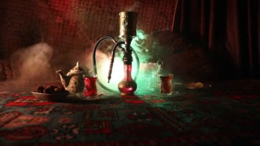 Nargile kömürü nargile kupa Arap iç de buhar bulutları yapma. Şark süsleme halı Doğu çay töreni üzerinde. Şık oryantal shisha içinde karanlık arka ışık ile. Kaymak vurdu