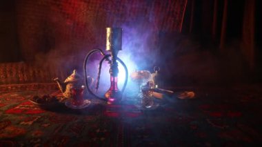Nargile kömürü nargile kupa Arap iç de buhar bulutları yapma. Şark süsleme halı Doğu çay töreni üzerinde. Şık oryantal shisha içinde karanlık arka ışık ile. Kaymak vurdu
