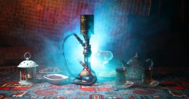 Nargile kömürü nargile kupa Arap iç de buhar bulutları yapma. Şark süsleme halı Doğu çay töreni üzerinde. Şık oryantal shisha içinde karanlık arka ışık ile. Kaymak vurdu